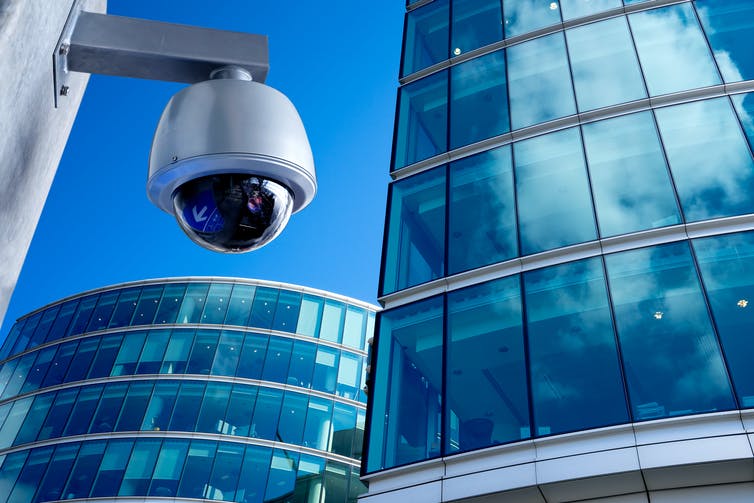 A CCTV camera in a city centre surrounded by high-rise offices