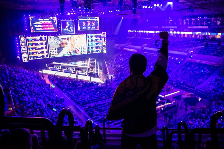 Fan standing up in mass audience for esports event in Moscow