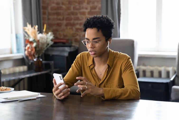 A young woman looks at her smartphone.