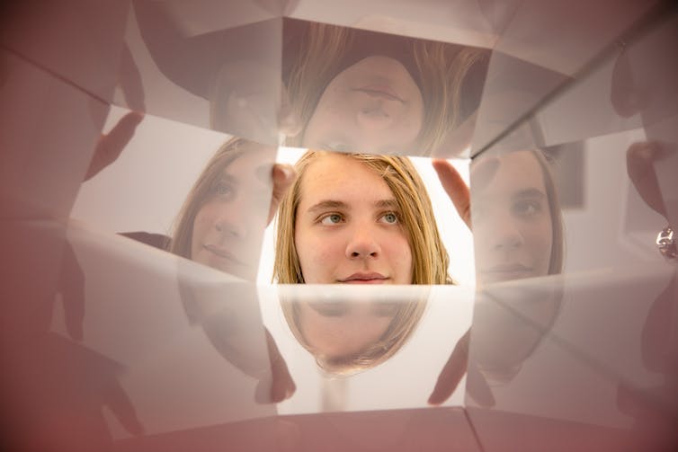 young person looks into mirrored chamber