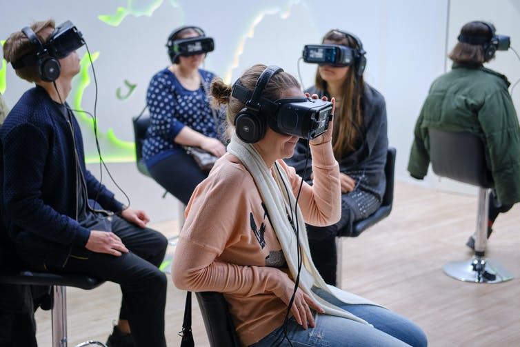 People in a room wearing VR headsets.