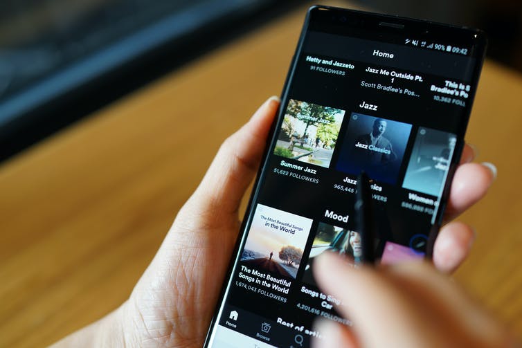 Close up of a phone with the Spotify application on the screen.