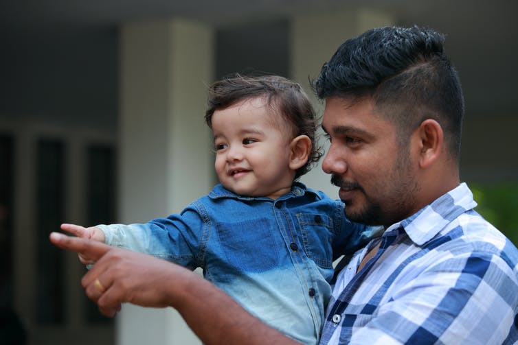 Father pointing with young son.