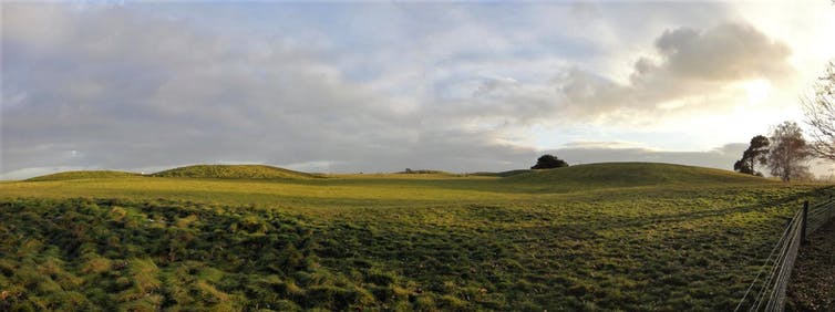 Landscape photograph showing burial mounds in grass