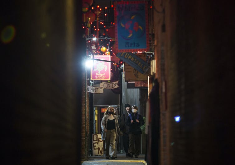 Teens walk in an alley.