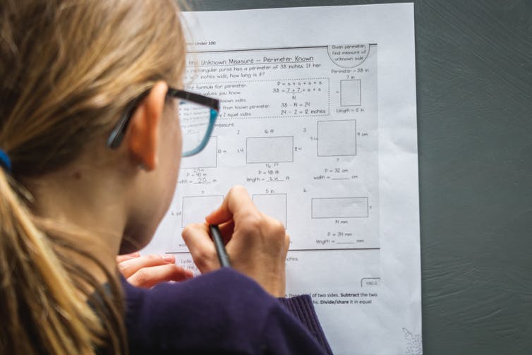 A girl works on a maths worksheet.