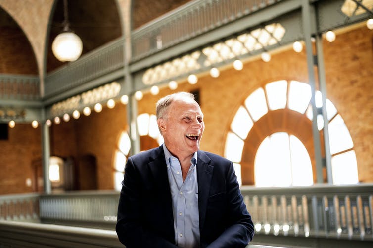 David Card laughs as he leans against a balcony on campus in Berkeley, California.