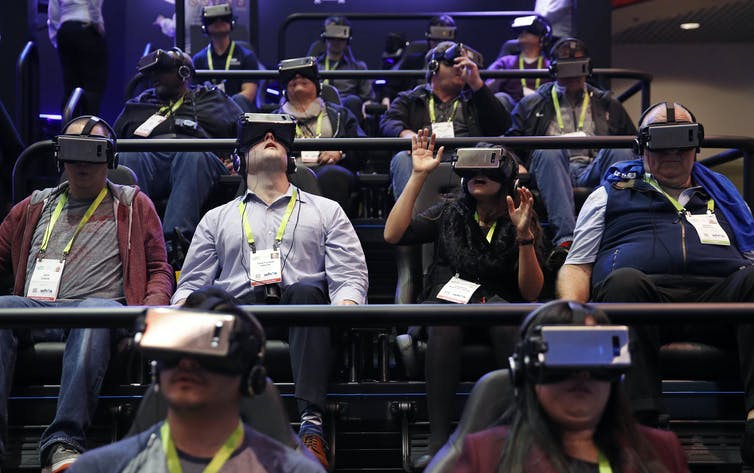 An audience wearing virtual reality headsets.