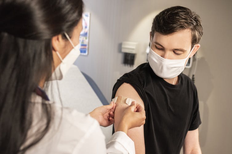 A young man receives a vaccine.