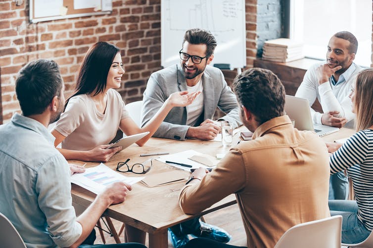 A group of professionals having a discussion at a boardroom table.