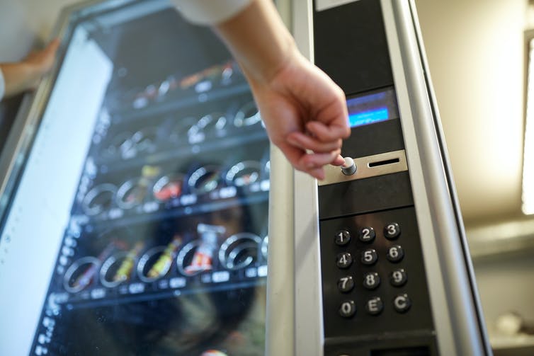 Person selecting snack from vending machine