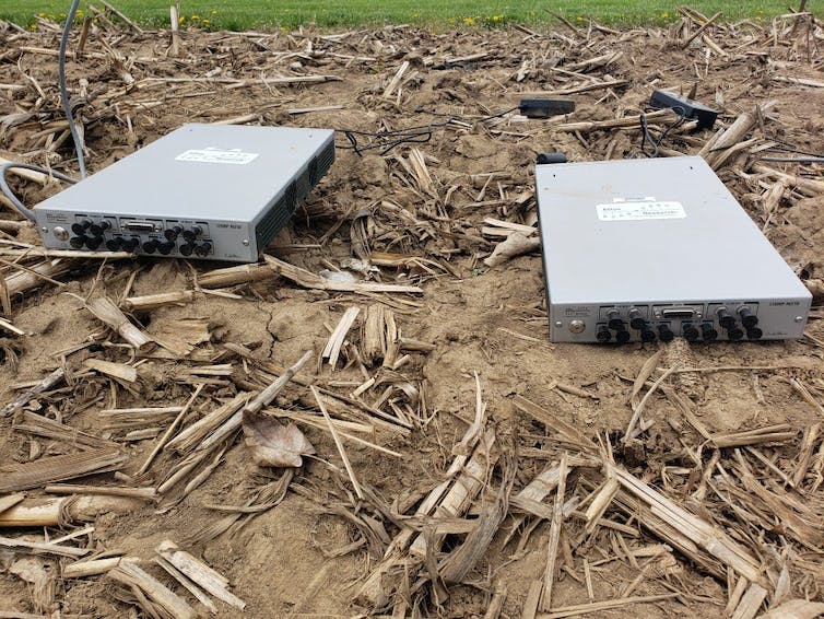 Two metal radios on the ground