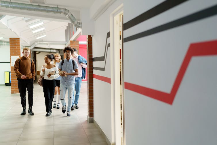 Teens seen walking through a corridor.