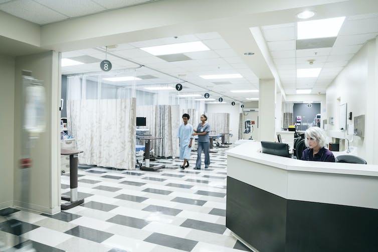 brightly lit area of a hospital with workers and patients