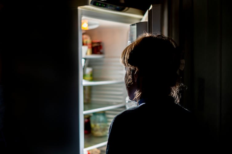 A young person looks in a fridge.