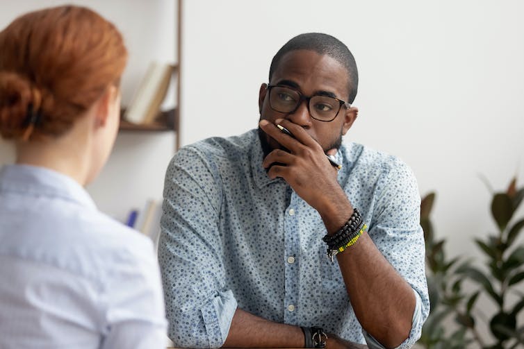 Doubtful HR manager talking to an applicant at job interview