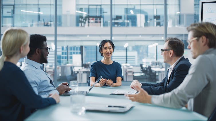 A woman sitting at the head of a board meeting