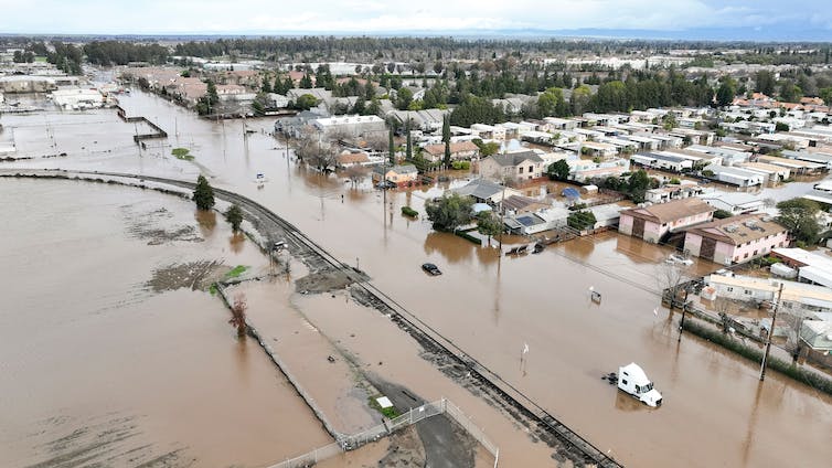 All the streets are flooded and a semi and cars sit stranded in water.