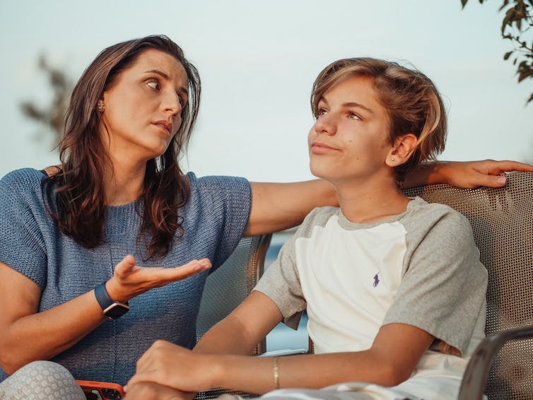 Mother discussing tricky topic with disinterested teenage son