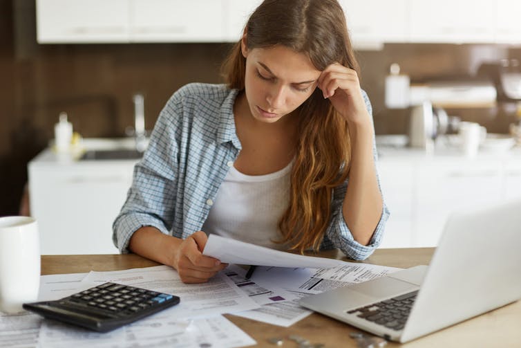 Woman looking at bills anxiously