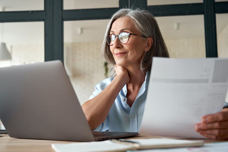 Woman with laptop and papers.