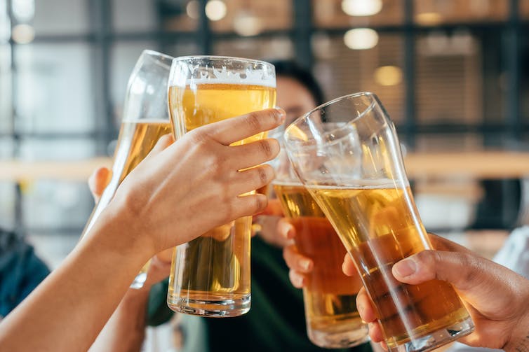 People clinking beer glasses