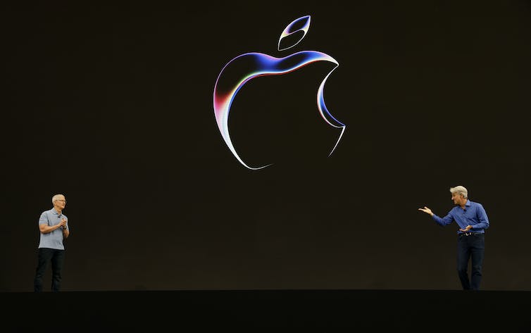 Tim Cook (L) and Apple Senior VP of Software Engineering Craig Federighi speak during the conference keynote address.