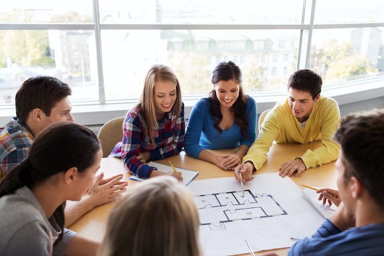 students sitting around a blueprint