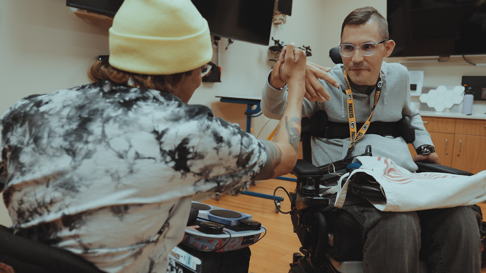 Two Xbox Adaptive Controller users high-fiving one another at Craig Hospital’s adaptive game night.