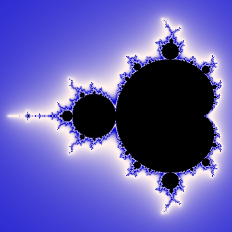 The Mandelbrot set, a mathematical fractal, shown in black against a blue background. The edges of the fractal are blue and white