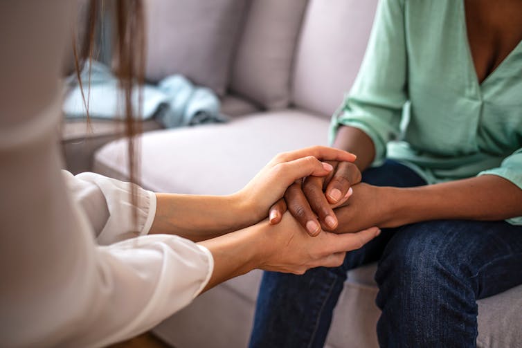 One person placing their hands around another's.