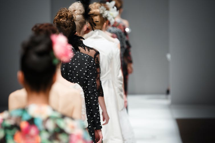 a row of models walking down a catwalk