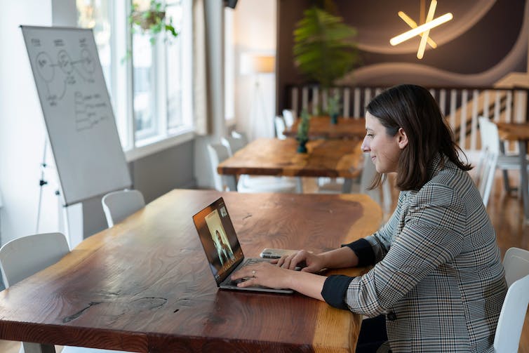 A woman looks at a computer screen monitor