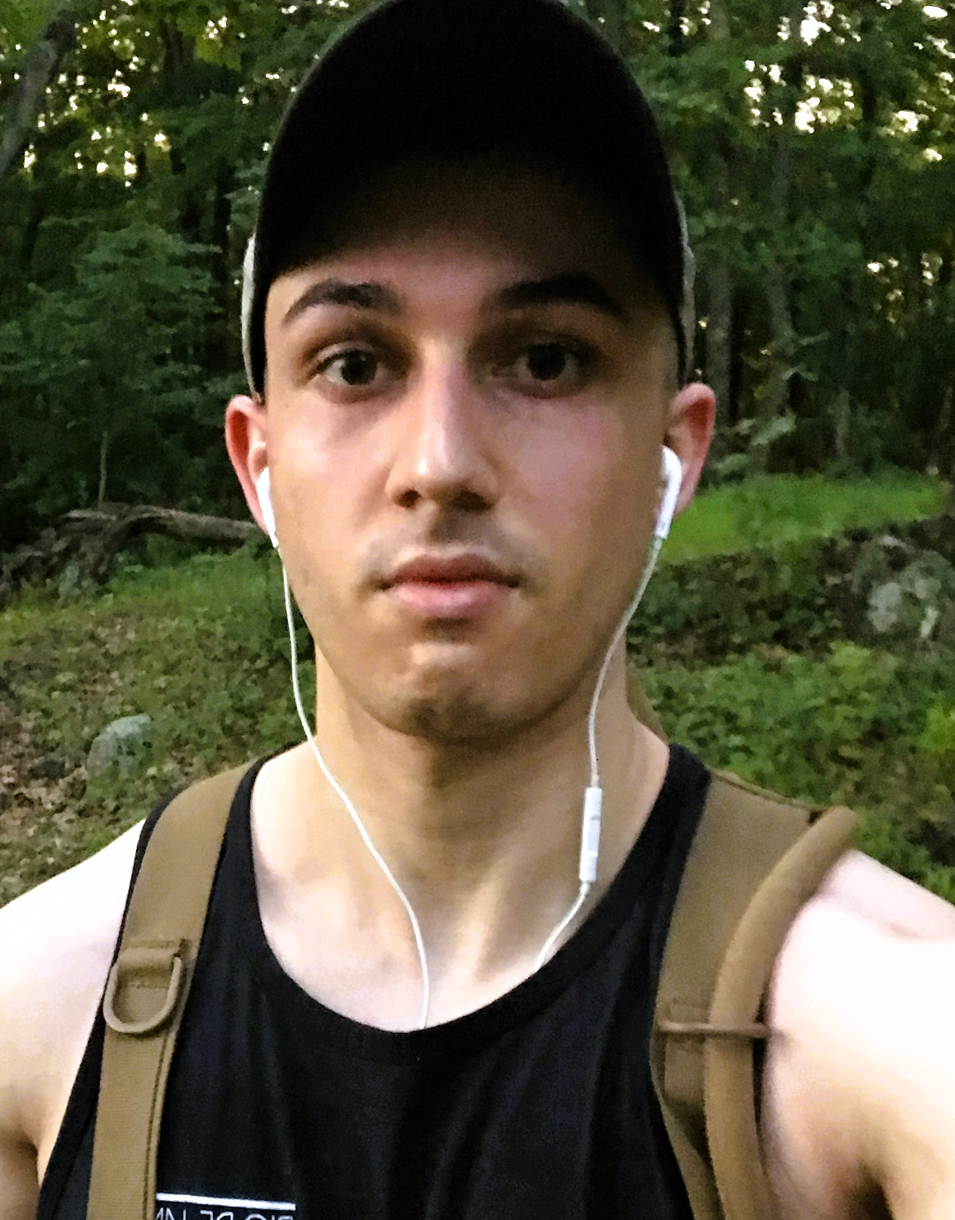 Portrait of Elder Elgin standing in a forested area.