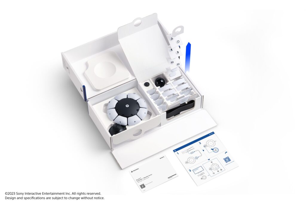 Image showing the Access controller packaging for PS5 open, revealing the contents. The instruction booklets are laid out in front