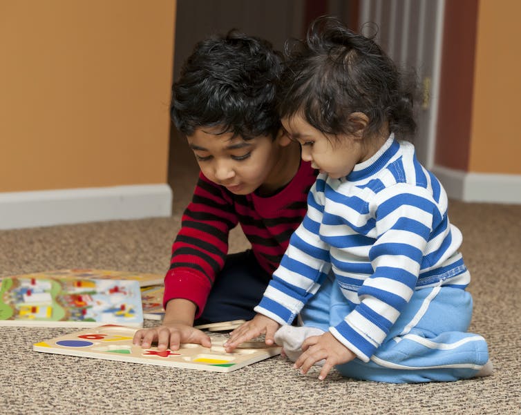 Two small children playing with shapes