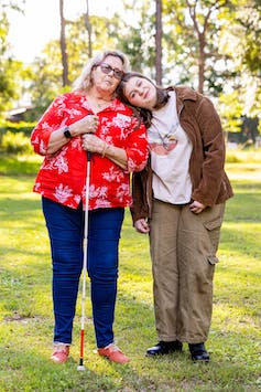 Dale and Abi outside, standing on grass, trees in background