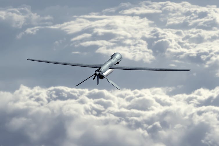 an unmanned drone looking like a slim small airplane among clouds