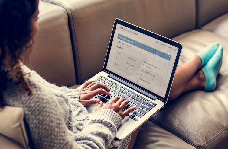 a woman sitting on a sofa on a laptop