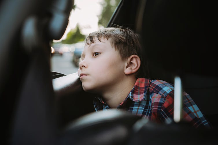 Tired boy looks out the window