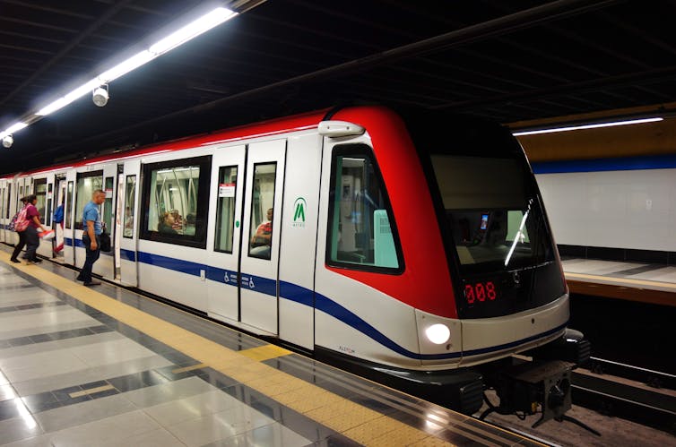 People on a metro platform getting onto an underground train.