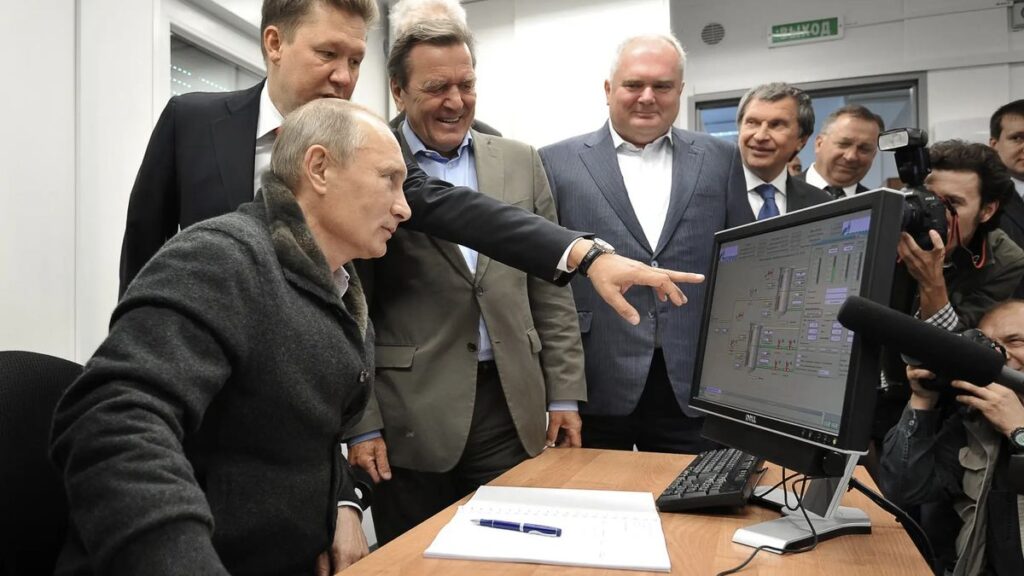 Vladimir Putin being shown something on a computer monitor