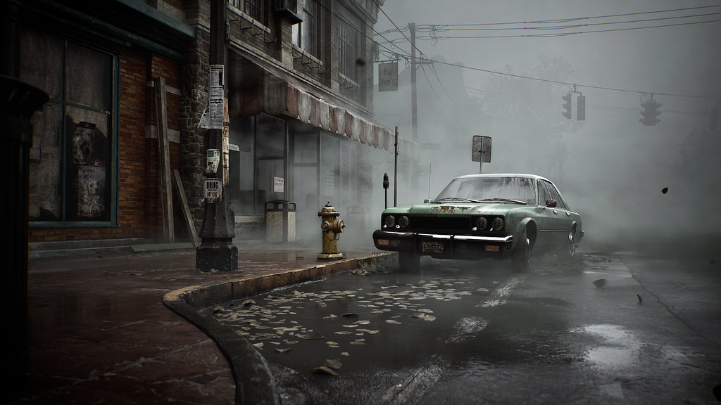 This image shows a deserted street in Silent Hill. A green car with white roof is parked at the side of the road, its rear partially shrouded by an ominous fog.