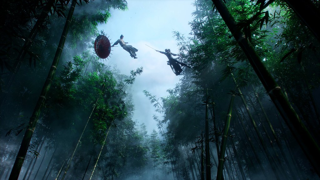 In this image, two characters do battle atop trees in a bamboo forest. One darts forward into the air, sword pointed. The other dives back out of harm’s way while clutching an opened umbrella.