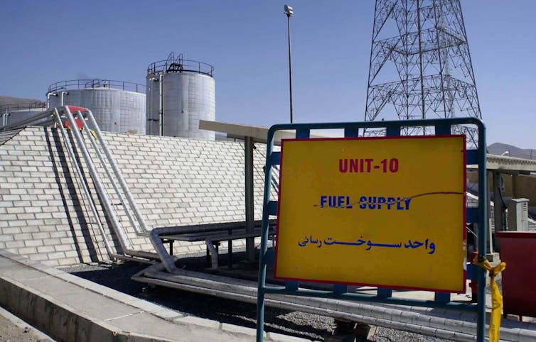 An exterior of industrial building with a sign in front of it.