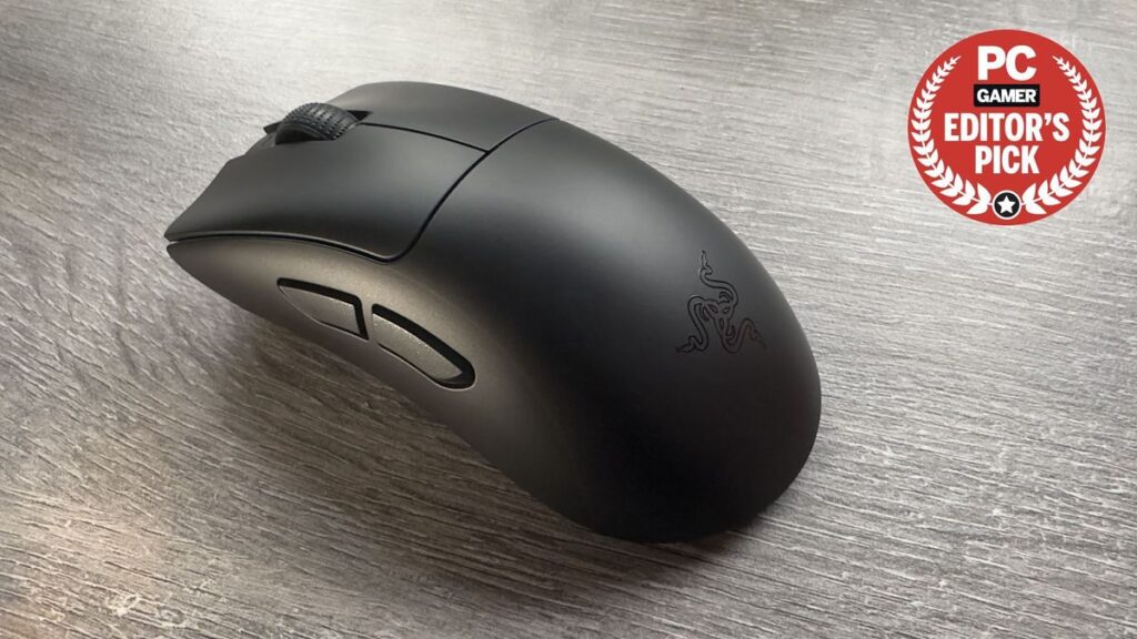 A photo of a Razer DeathAdder V3 HyperSpeed gaming mouse resting on an office desk, with a PCGamer Editor