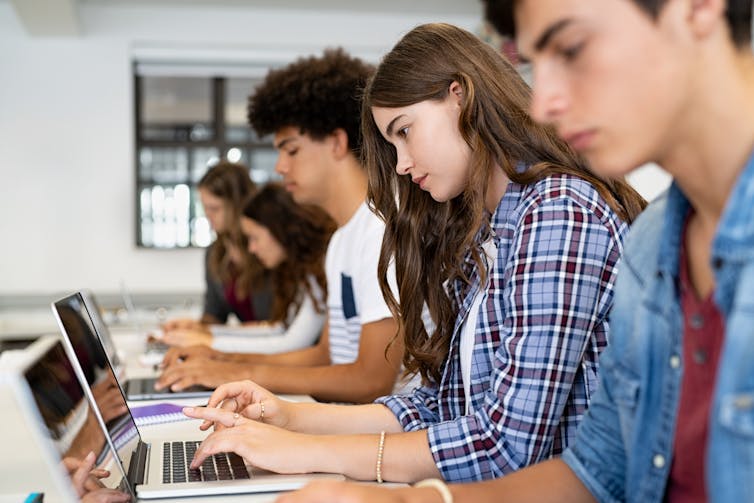 Students using laptops in classroom