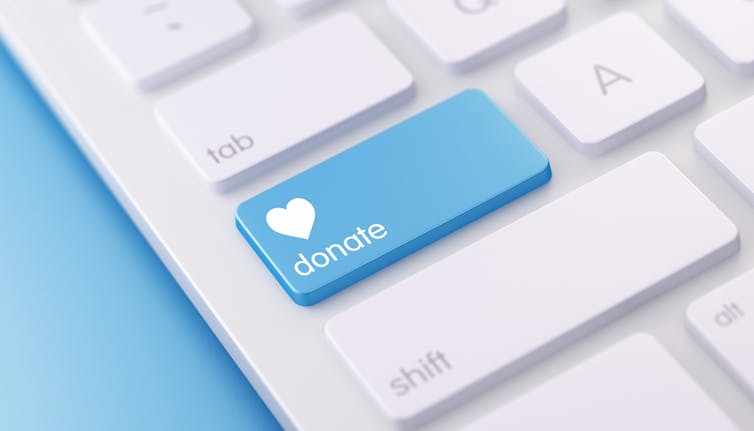 A modern white keyboard with blue colored Donate button.