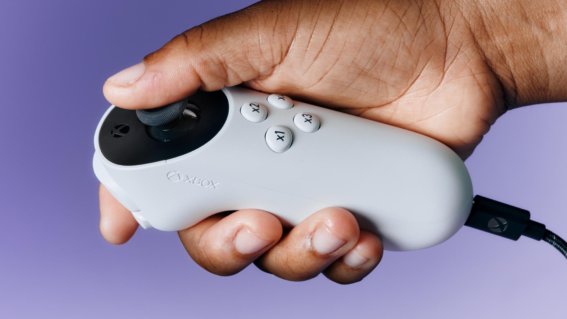 A hand holding the Adaptive Joystick accessory