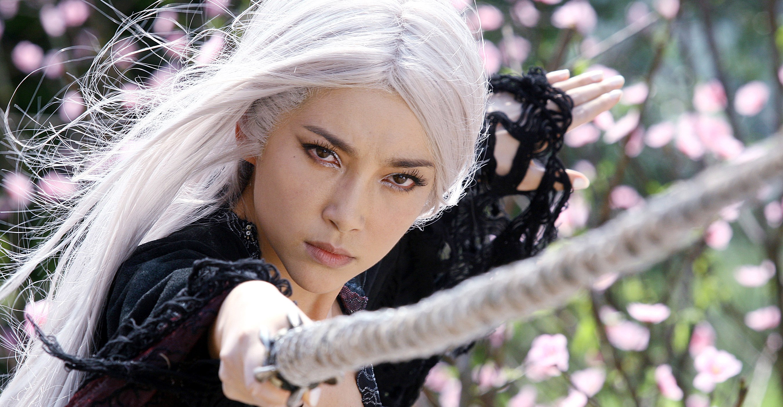 A woman with white hair holds a weapon toward the screen in The Forbidden Kingdom